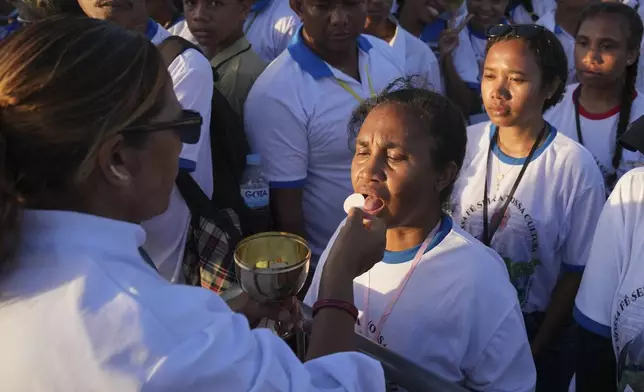 Faithful receive communion during the holy mass lead by Pope Francis at Tasitolu park in Dili, East Timor, Tuesday, Sept. 10, 2024. (AP Photo/Dita Alangkara, Pool)