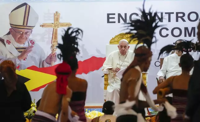 Pope Francis looks at traditional dancers as he arrives at the Centro de Convenções in Díli, East Timor, Wednesday, Sept. 11, 2024, for a meeting with young people. The Vatican says some 600,000 people have attended Pope Francis' Mass in East Timor, or nearly half the country's population, on Tuesday on the same field where St. John Paul II prayed in 1989 during the nation's fight for independence from Indonesia. (AP Photo/Gregorio Borgia)