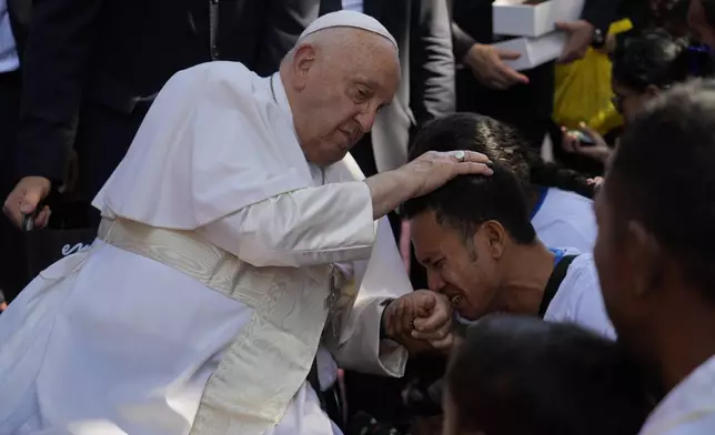 Pope Francis consoles a person during a visit at the 'Irmas ALMA' (Sisters of the Association of Lay Missionaries) School for Children with Disabilities in Dili, East Timor, Tuesday, Sept. 10, 2024. Pope Francis has indirectly acknowledged the abuse scandal in East Timor involving its Nobel Peace Prize-winning independence hero Bishop Carlos Filipe Ximenes Belo. (AP Photo/Gregorio Borgia)