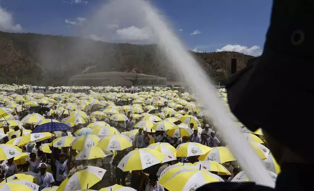 A firefighter sprays water on Catholic faithful gathered for a Holy Mass with Pope Francis at the Esplanade of Taci Tolu in Dili, East Timor, Tuesday, Sept.10, 2024. (Willy Kurniawan/Pool Photo via AP)