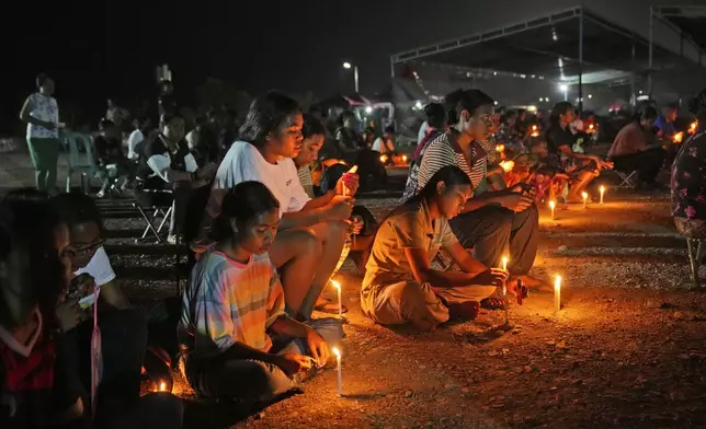 People coming from Oecusse, about 200 kilometers (124 miles) from the capital of Dili, light candles during an evening mass on the field where they camp for days while waiting to attend the holy mass presided by Pope Francis scheduled on Sept. 10, in Dili, East Timor, Sunday, Sept. 8, 2024. (AP Photo/Dita Alangkara)