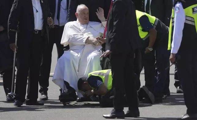 An airport staff kisses the Pope Francis' foot at Dili Presidente Nicolau Lobato International Airport in Dili, East Timor, Monday, Sept. 9, 2024. (AP Photo/Dita Alangkara)