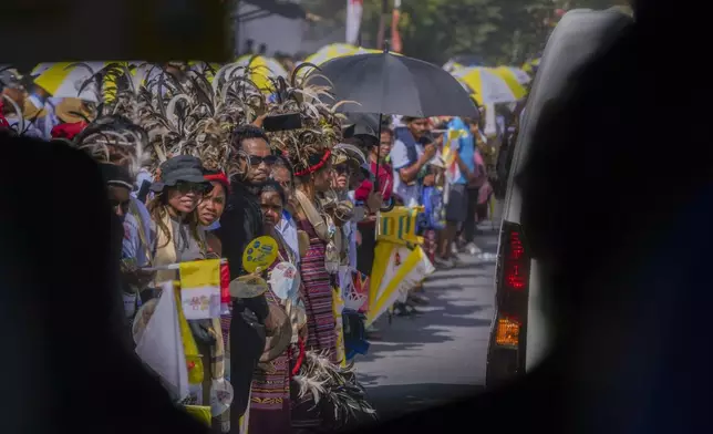 People wait along a road where Pope Francis is expected to pass on his way from the Dili's Presidente Nicolau Lobato International Airport to the Apostolic nunciature in Dili, East Timor, Monday, Sept. 9, 2024. Pope Francis arrived in East Timor on Monday to encourage its recovery from a bloody and traumatic past and celebrate its development after two decades of independence from Indonesian rule. (AP Photo/Gregorio Borgia)