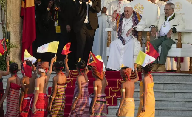 Pope Francis cheers at children in traditional dress as he attends with East Timor's President José Manuel Ramos-Horta, a welcome ceremony outside the Presidential Palace in Dili, East Timor, Monday, Sept. 9, 2024. Pope Francis arrived in East Timor on Monday to encourage its recovery from a bloody and traumatic past and celebrate its development after two decades of independence from Indonesian rule. (AP Photo/Gregorio Borgia)