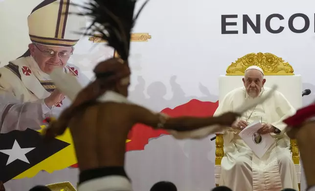 Pope Francis looks at traditional dancers as he arrives at the Centro de Convenções in Díli, East Timor, Wednesday, Sept. 11, 2024, for a meeting with young people. The Vatican says some 600,000 people have attended Pope Francis' Mass in East Timor, or nearly half the country's population, on Tuesday on the same field where St. John Paul II prayed in 1989 during the nation's fight for independence from Indonesia. (AP Photo/Gregorio Borgia)