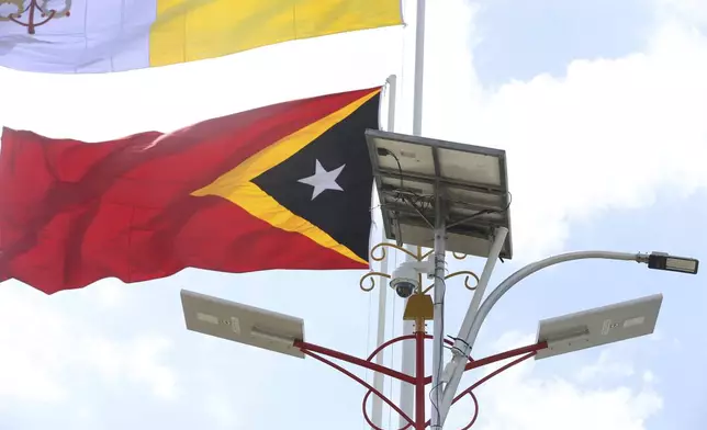 A solar panel is seen next to an East Timor national flag in Dili, East Timor, Friday, Sept. 6, 2024. (AP Photo/Firdia Lisnawati)