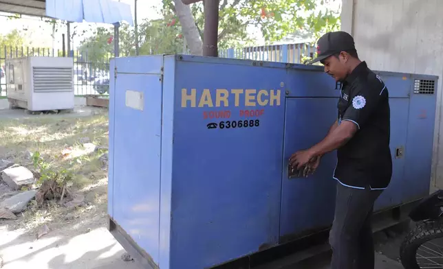 A man stands next to a generator at an office in Dili, East Timor, Friday, Sept. 6, 2024. (AP Photo/Firdia Lisnawati)