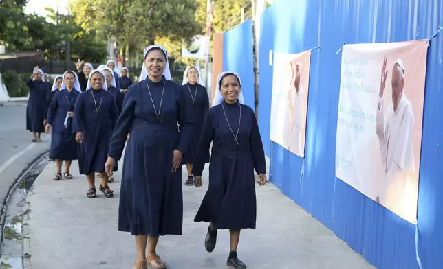 Nuns walk pass banners welcoming Pope Francis in Dili, East Timor on Saturday, Sept. 7, 2024. (AP Photo/Firdia Lisnawati)