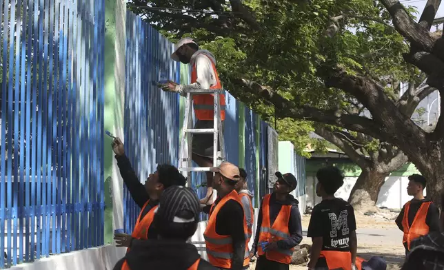 Volunteers paint a fence in preparation of the arrival of Pope Francis in Dili, East Timor, Friday, Sept. 6, 2024. (AP Photo/Firdia Lisnawati)