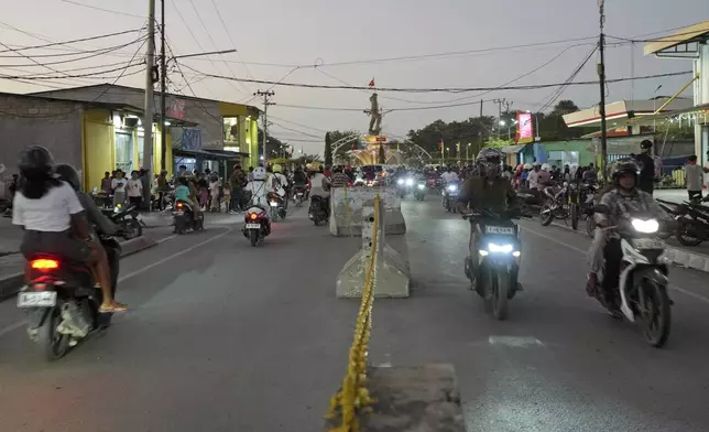 Motorcyclists move along a street where vendors have been removed in preparation of the visit of Pope Francis in Dili, East Timor on Sunday, Sept. 8, 2024. (AP Photo/Firdia Lisnawati)