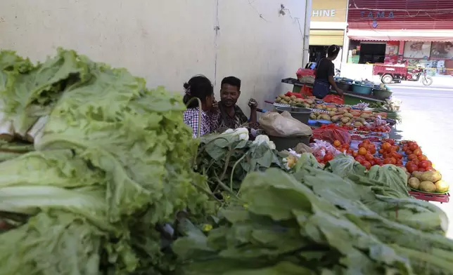 Vegetable vendors who were removed from a street wait for customers in Dili, East Timor, Saturday, Sept. 7, 2024. (AP Photo/Firdia Lisnawati)