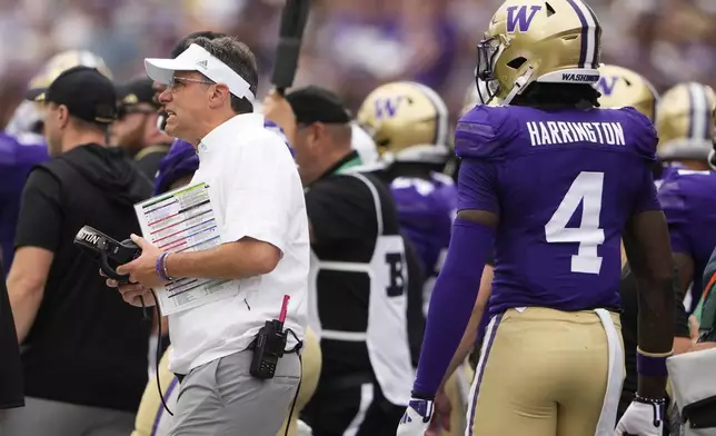 Washington head coach Jedd Fisch looks on from the sideline as safety Justin Harrington (4) walks by during the second half of an NCAA college football game against Eastern Michigan, Saturday, Sept. 7, 2024, in Seattle. Washington won 30-9. (AP Photo/Lindsey Wasson)