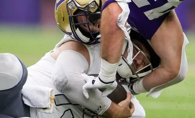 Washington's Carson Bruener (42) makes a late hit against Eastern Michigan quarterback Cole Snyder, left, during the first half of an NCAA college football game Saturday, Sept. 7, 2024, in Seattle. (AP Photo/Lindsey Wasson)