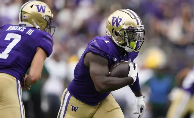 Washington quarterback Will Rogers (7) hands the ball off to running back Jonah Coleman for a 64-yard gain against Eastern Michigan during the first half of an NCAA college football game Saturday, Sept. 7, 2024, in Seattle. (AP Photo/Lindsey Wasson)