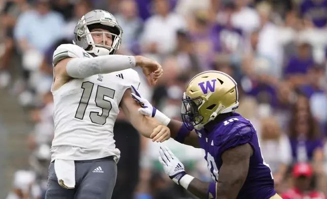 Washington edge Lance Holtzclaw commits a roughing the passer penalty on a tackle against Eastern Michigan quarterback Cole Snyder (15) during the second half of an NCAA college football game Saturday, Sept. 7, 2024, in Seattle. Washington won 30-9. (AP Photo/Lindsey Wasson)