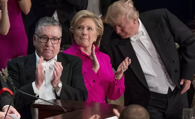 FILE - From left, Alfred E. Smith IV, Democratic presidential candidate Hillary Clinton, and Republican presidential candidate Donald Trump stand to applaud during the 71st annual Alfred E. Smith Memorial Foundation Dinner, Thursday, Oct. 20, 2016, in New York. (AP Photo/Andrew Harnik, File)