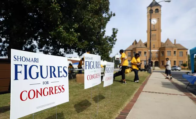 Campaign signs for Alabama's new 2nd Congressional District Democrat Shomari Figures decorate the lawn during the Macon County Day Festival in Tuskegee, Ala., on Saturday, Aug 31, 2024. (AP Photo/ Butch Dill)