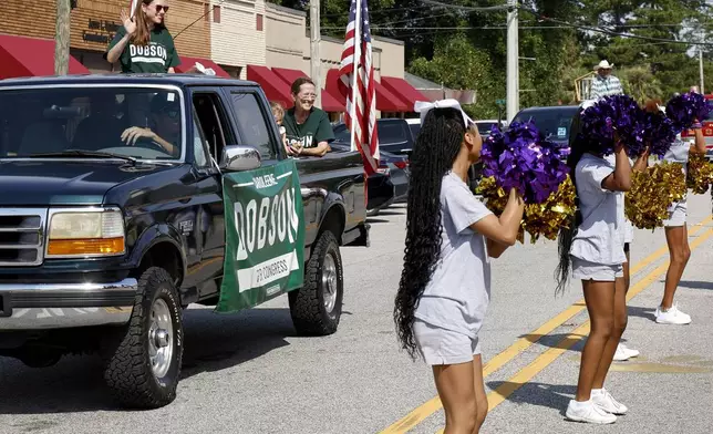 Alabama's new 2nd Congressional District Republican candidate Caroleene Dobson waves to the crowd as she rides in the parade during the Macon County Day Festival in Tuskegee, Ala., on Saturday, Aug 31, 2024. (AP Photo/ Butch Dill)