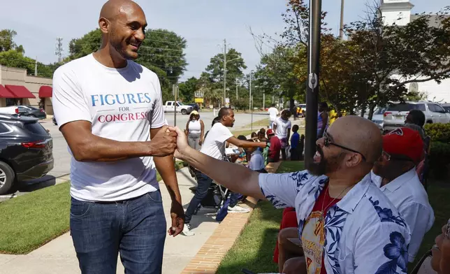 Alabama's new 2nd Congressional District Democratic candidate Shomari Figures greets voters during the Macon County Day Festival in Tuskegee, Ala., on Saturday, Aug 31, 2024. (AP Photo/ Butch Dill)