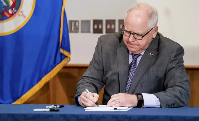 FILE - Gov. Tim Walz signs into law a sweeping package of police accountability measures in St. Paul, Minn., on July 23, 2020, including a ban on neck restraints, in the wake of George Floyd's death. (Glen Stubbe/Star Tribune via AP, File)