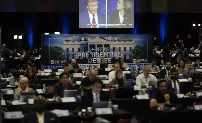 A presidential debate between Republican presidential nominee former President Donald Trump, on screen at left, and Democratic presidential nominee Vice President Kamala Harris, right, is seen from the spin room, Tuesday, Sept. 10, 2024, in Philadelphia. (AP Photo/Matt Rourke)