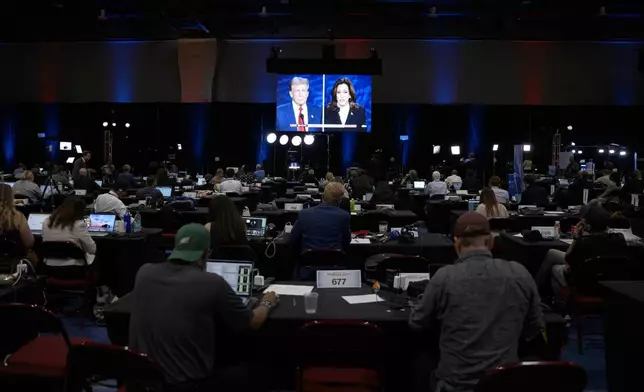 A presidential debate between Republican presidential nominee former President Donald Trump, on screen at left, and Democratic presidential nominee Vice President Kamala Harris, right, is seen from the spin room, Tuesday, Sept. 10, 2024, in Philadelphia. (AP Photo/Matt Slocum)