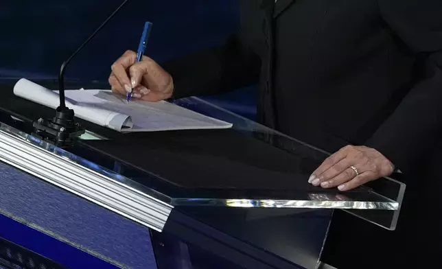 Democratic presidential nominee Vice President Kamala Harris writes notes during a break during a presidential debate with Republican presidential nominee former President Donald Trump at the National Constitution Center, Tuesday, Sept.10, 2024, in Philadelphia. (AP Photo/Alex Brandon)