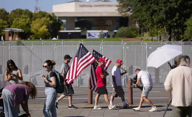 People gather across the street from the National Constitution Center, the site of tonight's presidential debate between Republican presidential nominee former President Donald Trump and Democratic presidential nominee Vice President Kamala Harris, Tuesday, Sept. 10, 2024, in Philadelphia. (AP Photo/Matt Slocum)