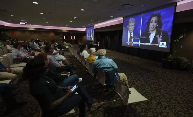 Ball State University students watch a presidential debate between Republican presidential nominee former President Donald Trump and Democratic presidential nominee Vice President Kamala Harris, Tuesday, Sept. 10, 2024, in Muncie, Ind. (AP Photo/Darron Cummings)