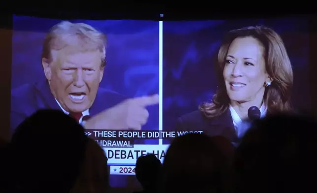 Republican presidential nominee former President Donald Trump, left, and Democratic presidential nominee Vice President Kamala Harris are seen on a screen during a presidential debate as people watch at One Longfellow Square, Tuesday, Sept. 10, 2024, in Portland, Maine. (AP Photo/Robert F. Bukaty)