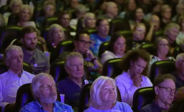 People watch the presidential debate between Republican presidential nominee former President Donald Trump and Democratic presidential nominee Vice President Kamala Harris at a 97-year-old movie theater Tuesday, Sept. 10, 2024, in Shawnee, Kan. (AP Photo/Charlie Riedel)