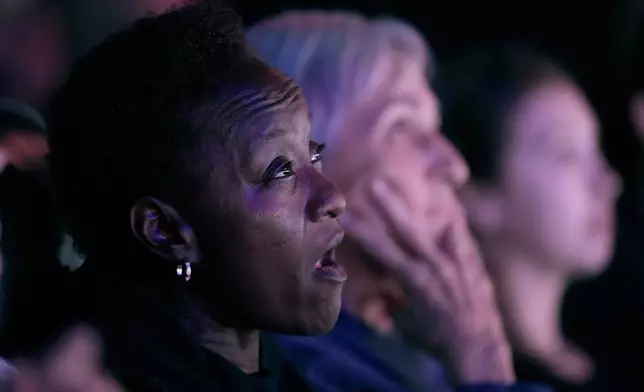 People watch the presidential debate between Republican presidential nominee former President Donald Trump and Democratic presidential nominee Vice President Kamala Harris at the Aztec theater Tuesday, Sept. 10, 2024, in Shawnee, Kan. (AP Photo/Charlie Riedel)