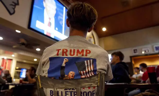 Evan Manni watches the presidential debate between Republican presidential nominee former President Donald Trump and Democratic presidential nominee Vice President Kamala Harris at Dan's Place, Tuesday, Sept. 10, 2024, in West Greenwich, R.I. (AP Photo/David Goldman)