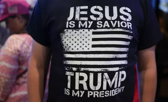 A supporter for Republican presidential nominee former President Donald Trump displays his t-shirt during a watch party at the Jonathan's Grille, Tuesday, Sept. 10, 2024, in Nashville, Tenn. (AP Photo/George Walker IV)