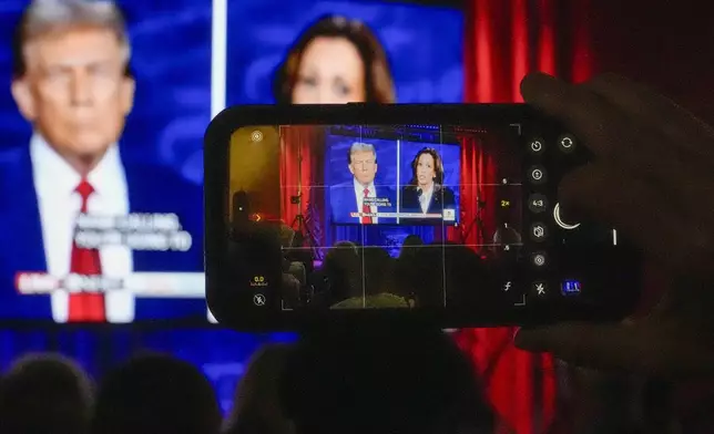 People gather at No Studios to watch the presidential debate between Republican presidential nominee former President Donald Trump and Democratic presidential nominee Vice President Kamala Harris, Tuesday, Sept. 10, 2024, in Milwaukee. (AP Photo/Morry Gash)