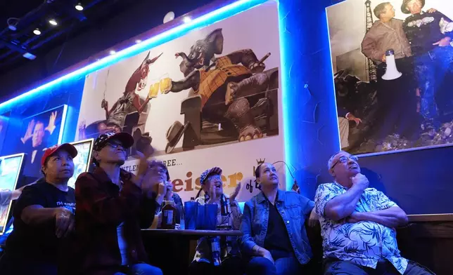 Monica Alvarez, second from left, joins other viewers gathered to watch a debate between Democratic presidential nominee Vice President Kamala Harris and Republican presidential nominee former President Donald Trump at the Angry Elephant Bar and Grill, Tuesday, Sept. 10, 2024, in San Antonio. (AP Photo/Eric Gay)