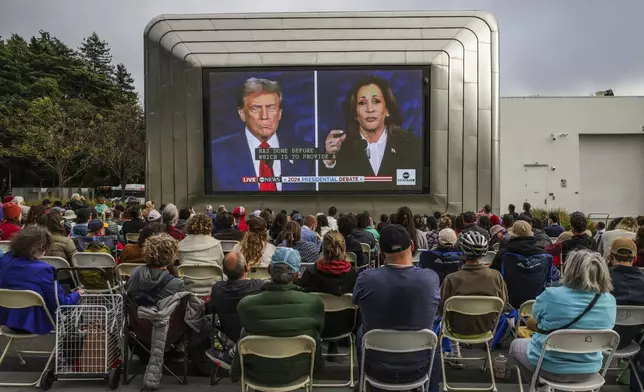 People gather outside of the Berkeley Art Museum and Pacific Film Archive to watch a presidential debate between Republican presidential nominee former President Donald Trump and Democratic presidential nominee Vice President Kamala Harris in Berkeley, Calif., Tuesday, Sept. 10, 2024. (Gabrielle Lurie/San Francisco Chronicle via AP)