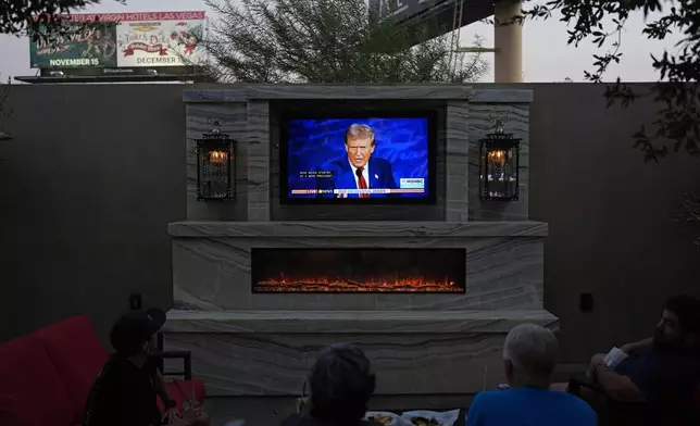 People watch the presidential debate between Republican presidential nominee former President Donald Trump and Democratic presidential nominee Vice President Kamala Harris, Tuesday, Sept. 10, 2024, at the Gipsy Las Vegas in Las Vegas. (AP Photo/John Locher)