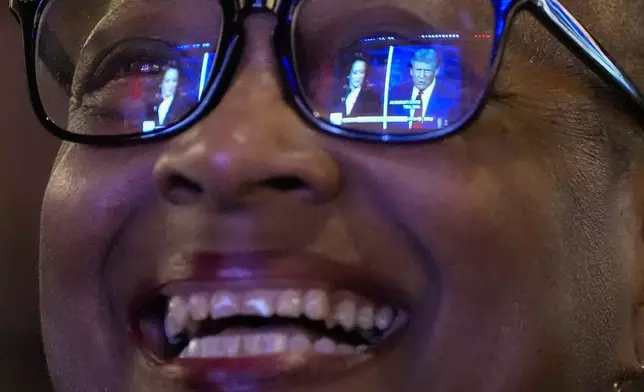 Sheena Carey laughs as she watches the presidential debate between Republican presidential nominee former President Donald Trump and Democratic presidential nominee Vice President Kamala Harris, Tuesday, Sept. 10, 2024, in Milwaukee. (AP Photo/Morry Gash)