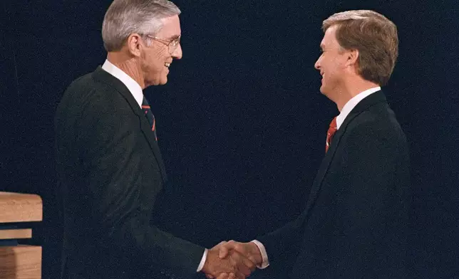 FILE - Sen. Lloyd Bentsen, D-Texas, left, shakes hands with Sen. Dan Quayle, R-Ind., before the start of their vice presidential debate at the Omaha Civic Auditorium, Omaha, Neb., Oct. 5, 1988. (AP Photo/Ron Edmonds, File)