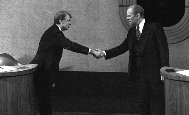 FILE - Jimmy Carter, left, and Gerald Ford, right, shake hands before the third presidential debate, Oct. 22, 1976, in Williamsburg, Va. (AP Photo/File)