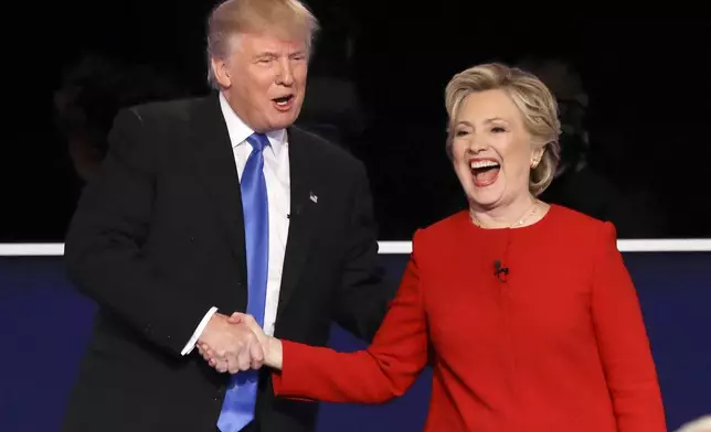 FILE - Republican presidential nominee Donald Trump, left, and Democratic presidential nominee Hillary Clinton shake hands after the presidential debate in Hempstead, N.Y., Sept. 26, 2016. (AP Photo/David Goldman, File)