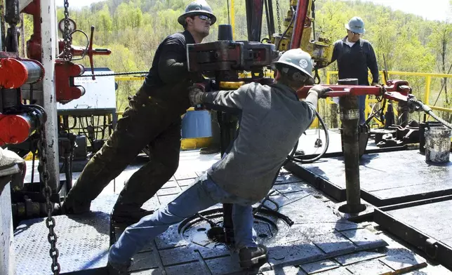 FILE - Workers move a section of well casing into place at a Chesapeake Energy natural gas well site near Burlington, Pa., in Bradford County, on April 23, 2010. (AP Photo/Ralph Wilson, File)