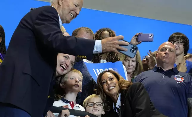 President Joe Biden take a photo as Democratic presidential nominee Vice President Kamala Harris poses as they campaign at the IBEW Local Union #5 union hall in Pittsburgh on Labor Day, Monday, Sept. 2, 2024. (AP Photo/Susan Walsh)