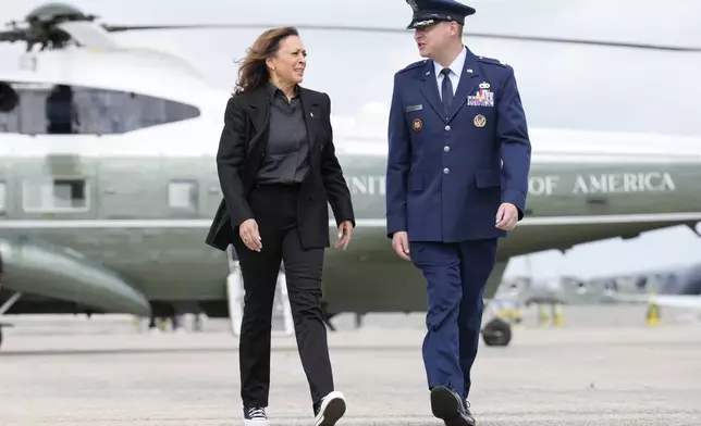 Democratic presidential nominee Vice President Kamala Harris, escorted by U.S. Air Force, Director of Flightline Protocol, Maj. Philippe Caraghiaur, walks to board Air Force Two, to travel to Pennsylvania for campaign events, Friday, Sept. 13, 2024, at Joint Base Andrews, Md. (AP Photo/Jacquelyn Martin)