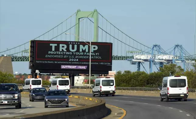 The motorcade of Democratic presidential nominee Vice President Kamala Harris passes a billboard in support of Republican presidential nominee former President Donald Trump Monday, Sept. 9, 2024, ahead of the presidential debate with Republican presidential nominee former President Donald Trump in Philadelphia. (AP Photo/Jacquelyn Martin)