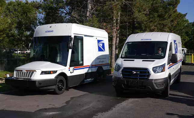 The U.S. Postal Service's next-generation delivery vehicle, left, is displayed as one new battery electric delivery trucks leaves the Kokomo Sorting and Delivery Center in Kokomo, Ind., Thursday, Aug. 29, 2024. (AP Photo/Michael Conroy)