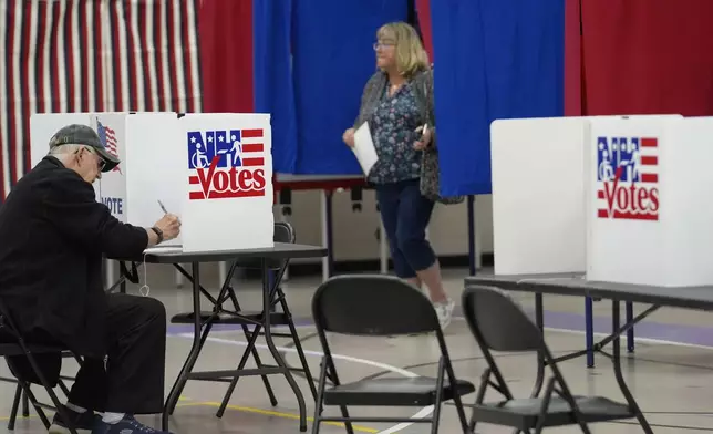 Voters fill out ballots, in a primary election to pick candidates for governor, the U.S. House, and the state Legislature, Tuesday, Sept. 10, 2024, in Nashua, N.H. (AP Photo/Steven Senne)