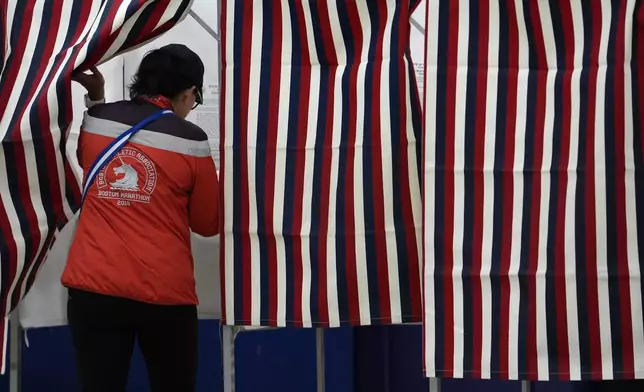 A voter enters a booth to fill out a ballot in a primary election to pick candidates for governor, the U.S. House, and the state Legislature, Tuesday, Sept. 10, 2024, in Nashua, N.H. (AP Photo/Steven Senne)