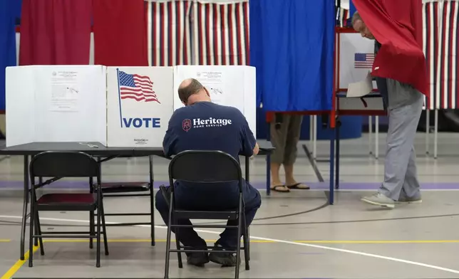 Voters fill out ballots, in a primary election to pick candidates for governor, the U.S. House, and the state Legislature, Tuesday, Sept. 10, 2024, in Nashua, N.H. (AP Photo/Steven Senne)